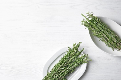 Flat lay composition with rosemary and space for text on light background. Aromatic herbs