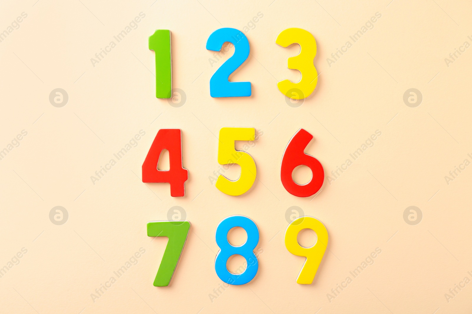 Photo of Colorful numbers on beige background, flat lay