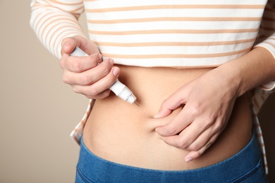 Photo of Woman doing insulin injection in stomach, closeup. Diabetes disease