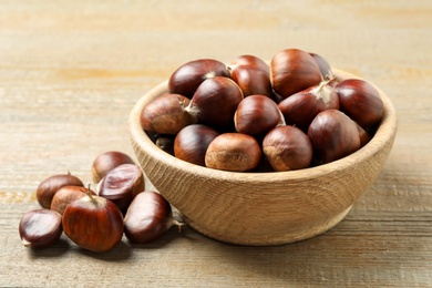 Photo of Fresh sweet edible chestnuts on wooden table