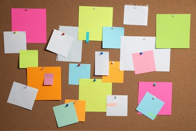 Photo of Many colorful notes pinned to cork board, closeup
