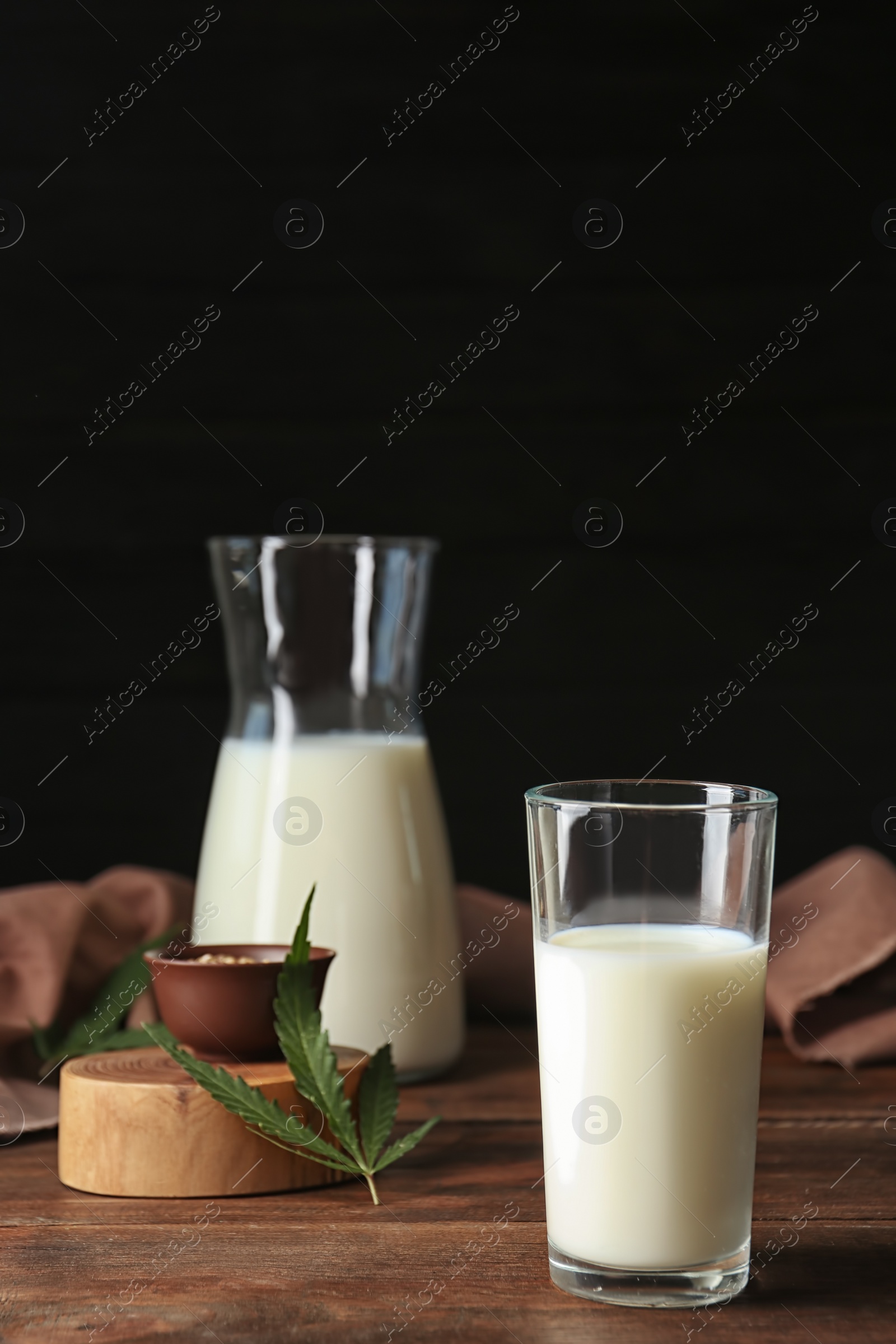 Photo of Glassware with hemp milk on wooden table