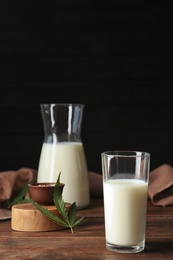 Glassware with hemp milk on wooden table