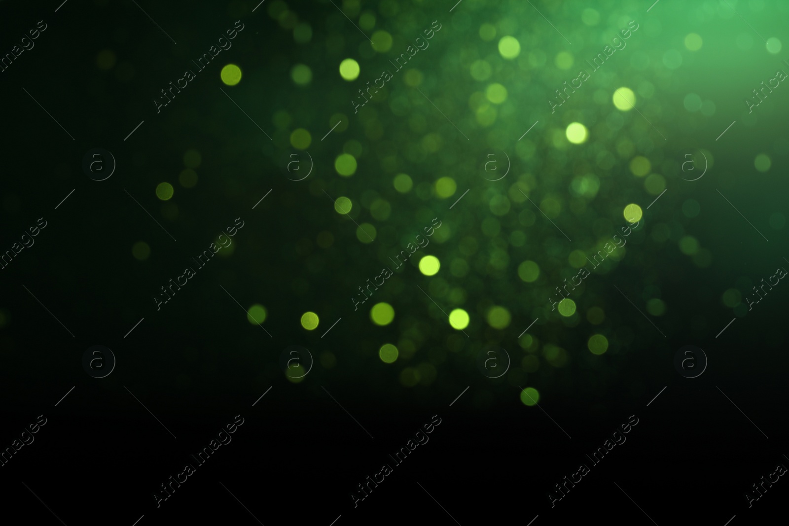 Photo of Blurred view of festive lights on green background. Bokeh effect