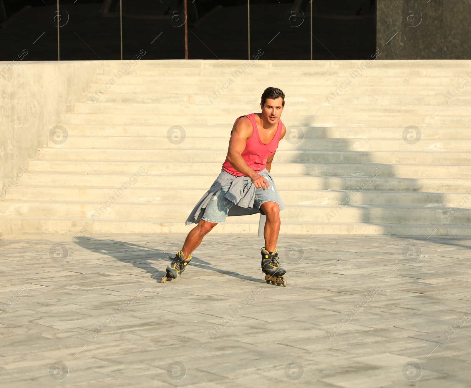 Photo of Handsome young man roller skating on city street