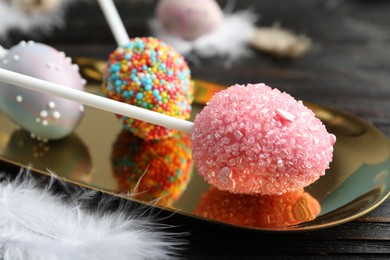 Photo of Delicious sweet cake pops on black wooden table, closeup. Easter holiday