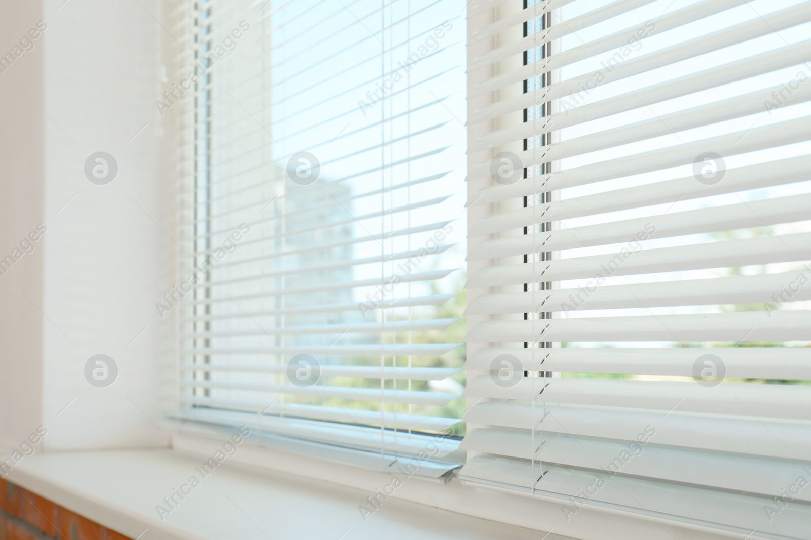 Photo of New modern window with blinds indoors. Home interior