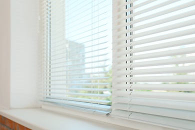 Photo of New modern window with blinds indoors. Home interior