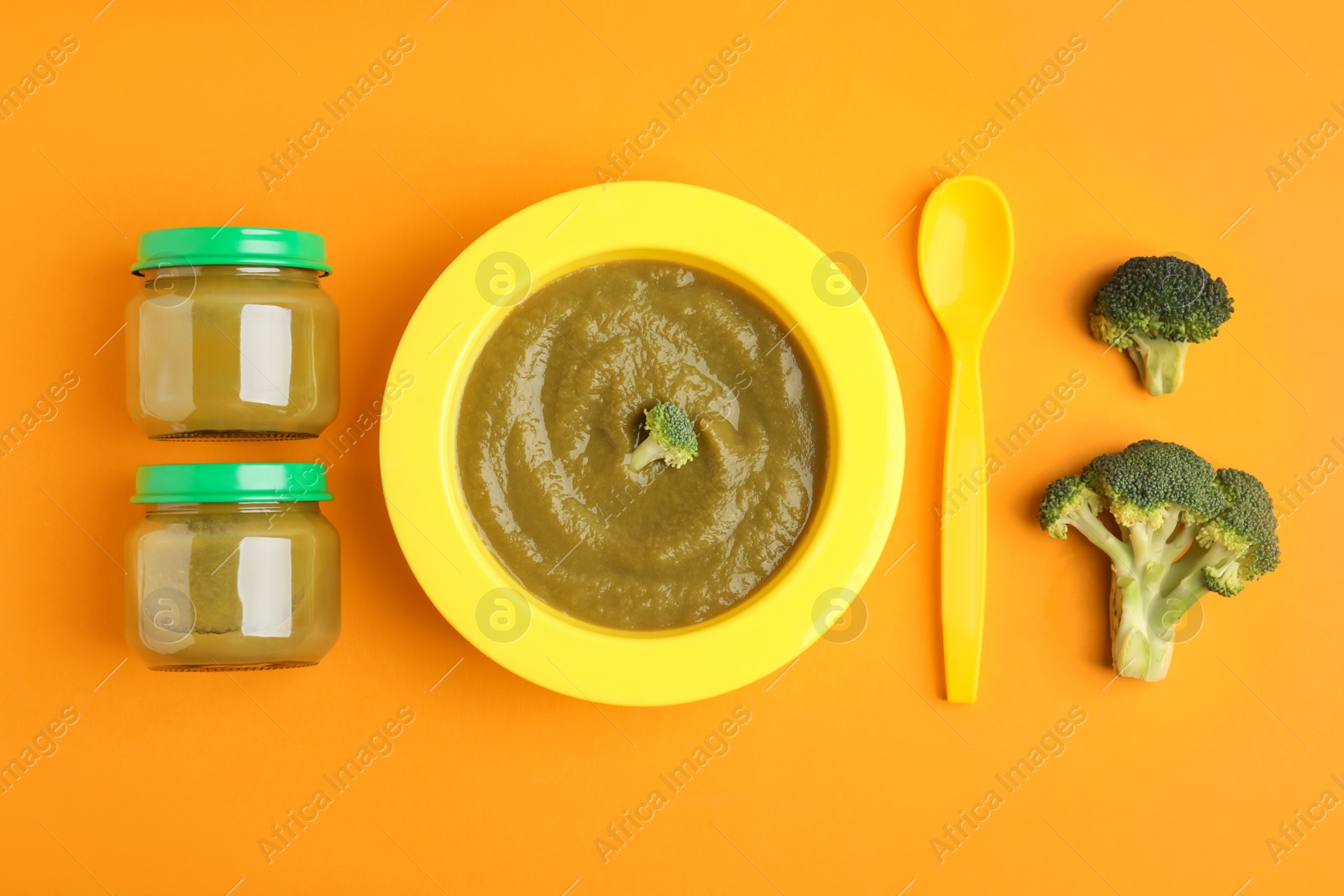 Photo of Flat lay composition with healthy baby food and broccoli on orange background