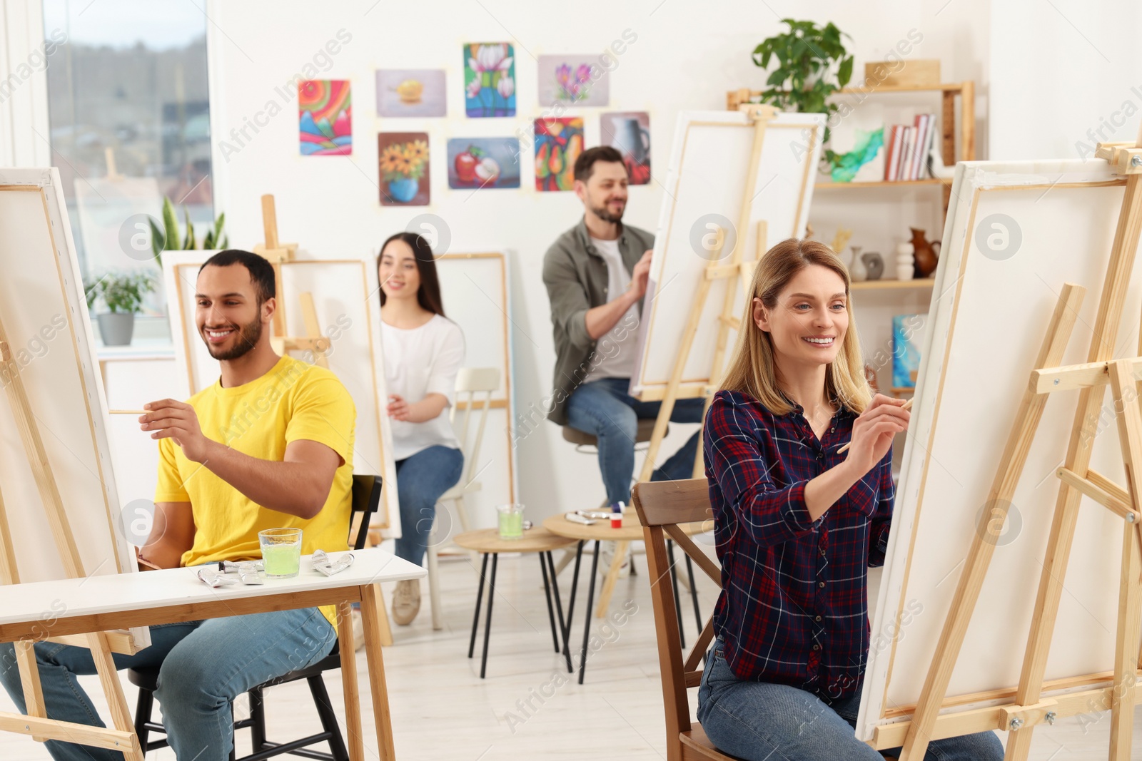 Photo of Group of students attending painting class in studio. Creative hobby