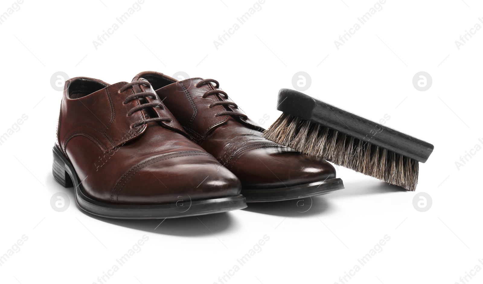 Photo of Stylish men's shoes and cleaning brush on white background