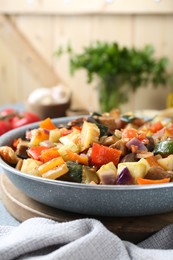 Photo of Delicious ratatouille in frying pan on board, closeup. Space for text