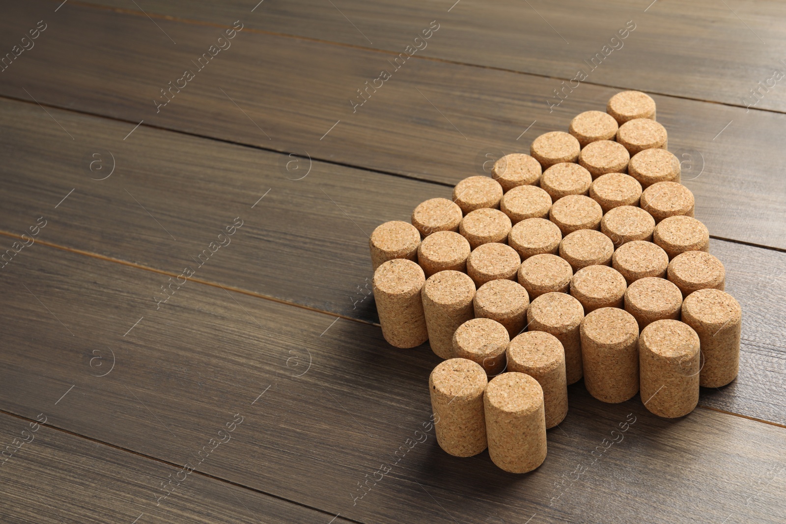 Photo of Christmas tree made of wine corks on wooden table. Space for text