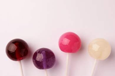 Photo of Tasty lollipops on white background, flat lay. Space for text