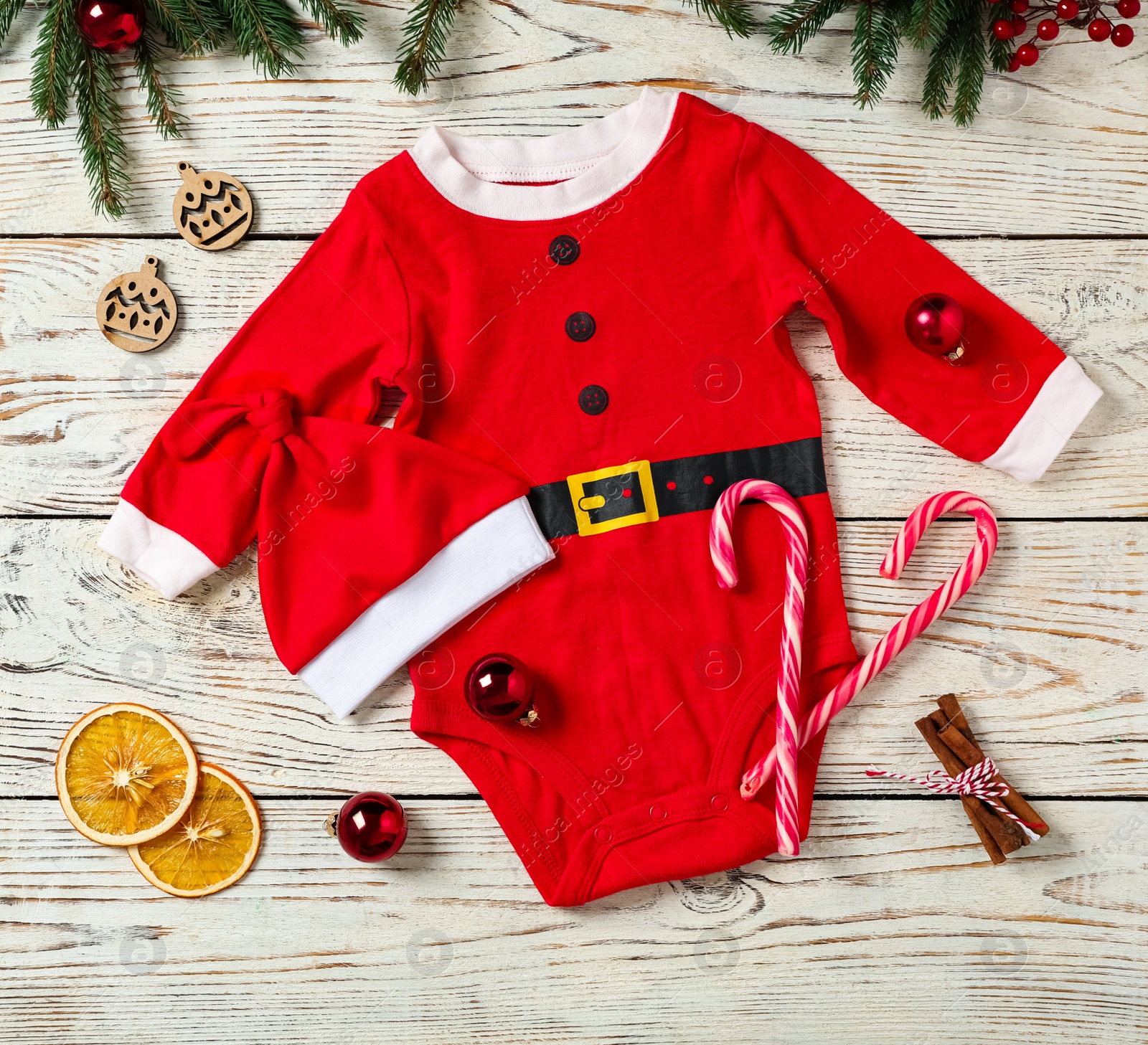 Photo of Flat lay composition with cute Christmas baby clothes on white wooden background