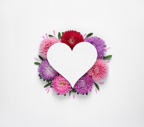 Composition with beautiful aster flowers and blank card on white background, top view. Space for text