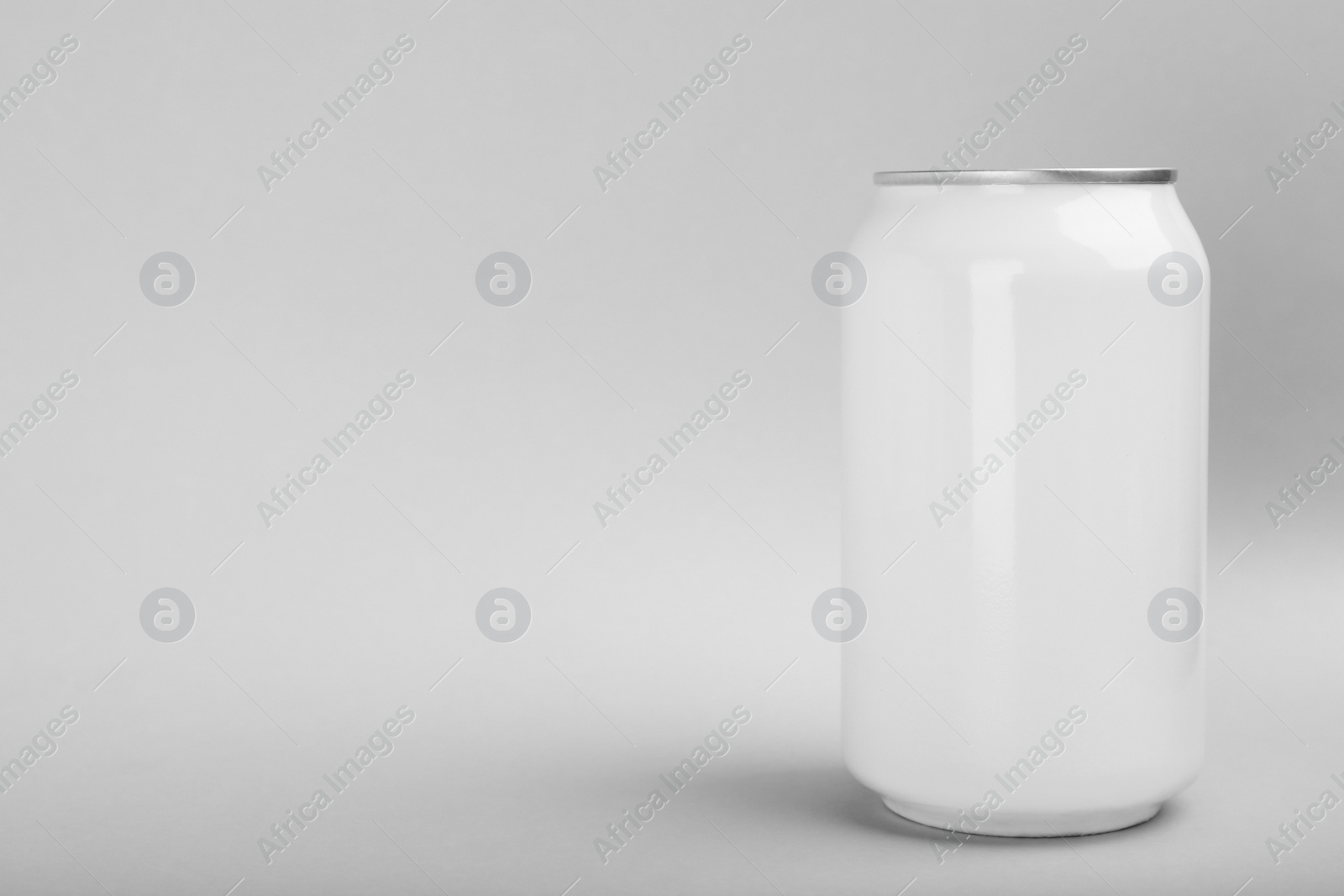 Photo of White can of energy drink on light grey background. Space for text