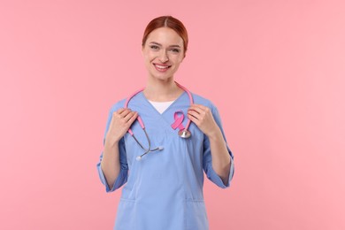 Photo of Mammologist with pink ribbon on color background. Breast cancer awareness