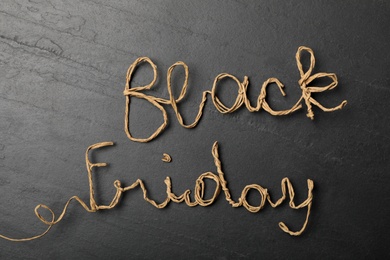 Photo of Phrase Black Friday made with rattan rope on dark background, top view
