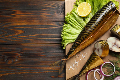 Photo of Tasty smoked fish on wooden table, top view. Space for text