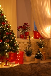 Room with Christmas decorations in evening. Festive interior design