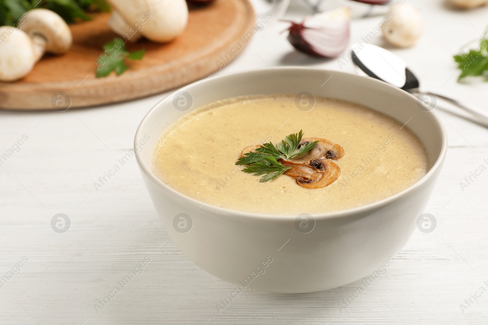 Photo of Bowl of fresh homemade mushroom soup on wooden table