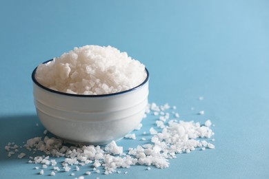 Photo of Organic salt in bowl on light blue background