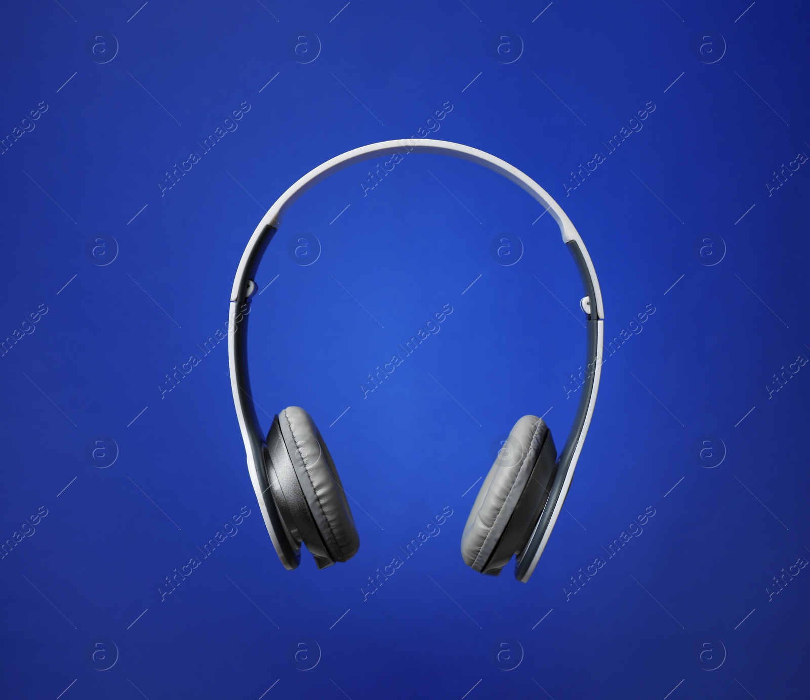 Photo of Stylish modern headphones with earmuffs on color background