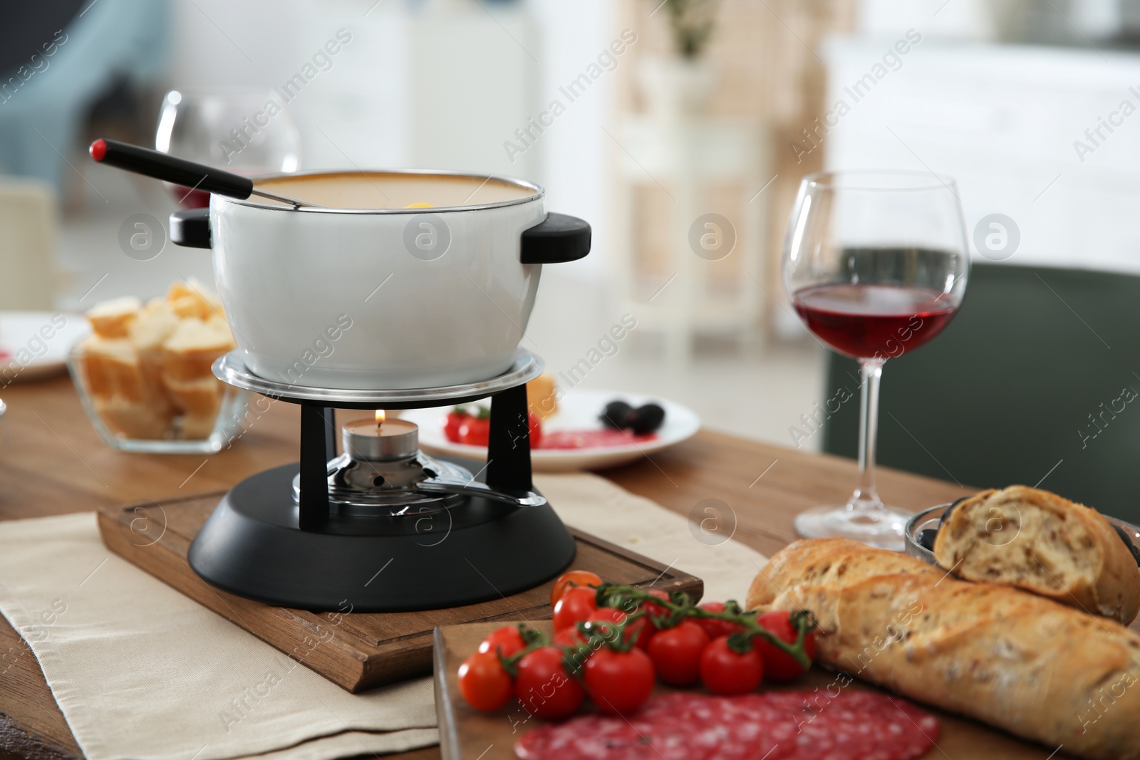 Photo of Fondue pot and different products on table indoors