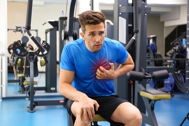 Young man having heart attack in gym