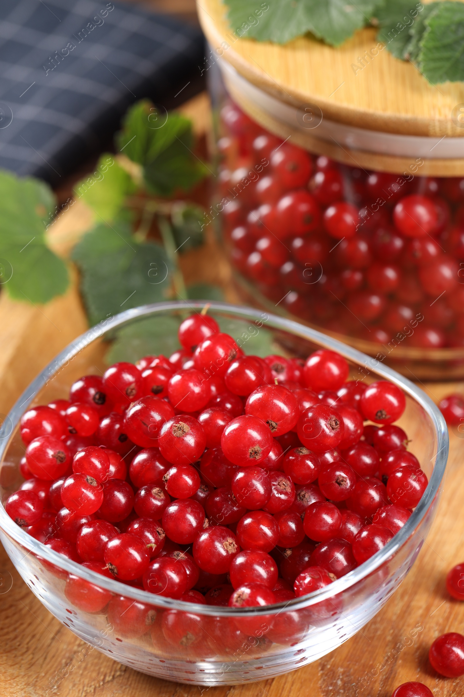 Photo of Ripe red currants and leaves on table, closeup