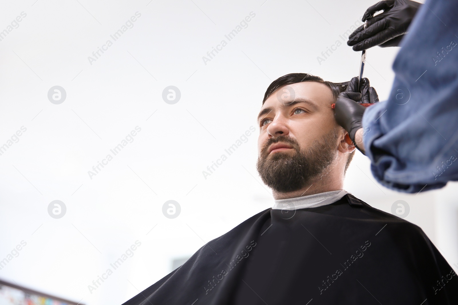 Photo of Professional barber working with client in hairdressing salon. Hipster fashion