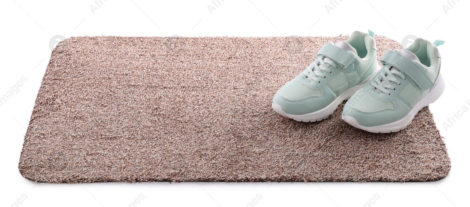 Photo of Stylish door mat with shoes on white background