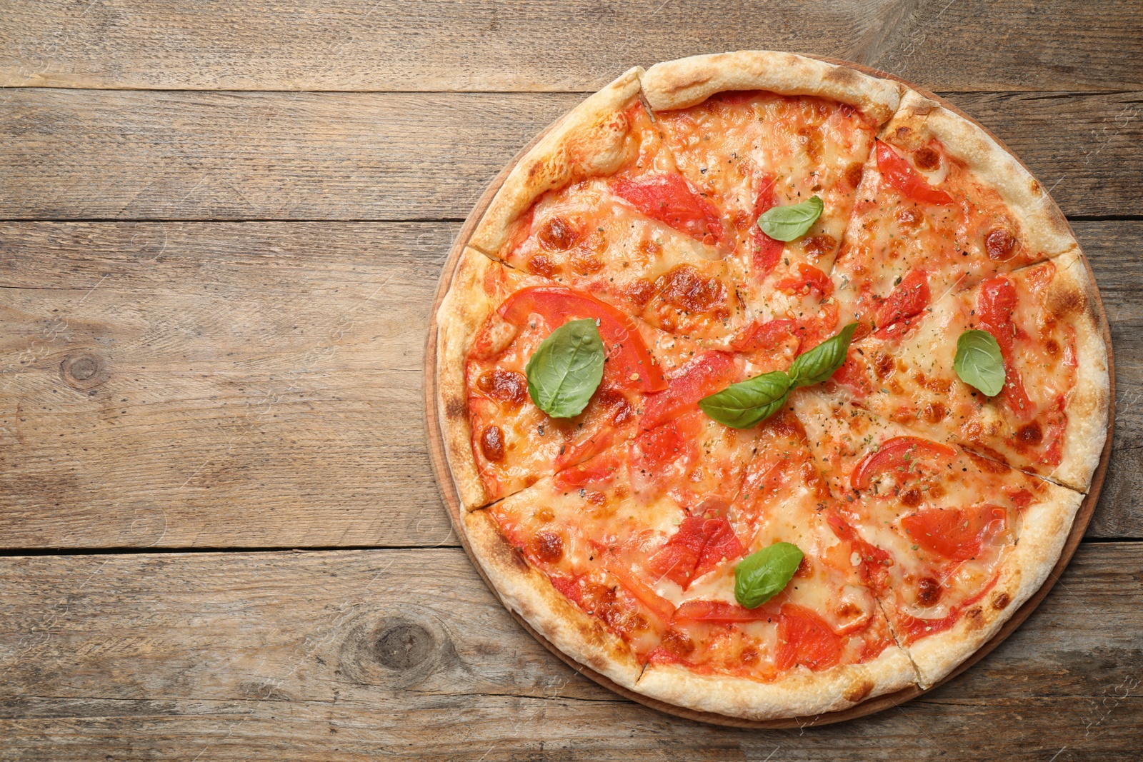 Photo of Delicious pizza Margherita on wooden table, top view. Space for text