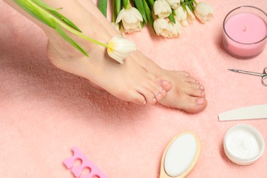 Photo of Woman with neat toenails after pedicure procedure on pink terry towel, closeup