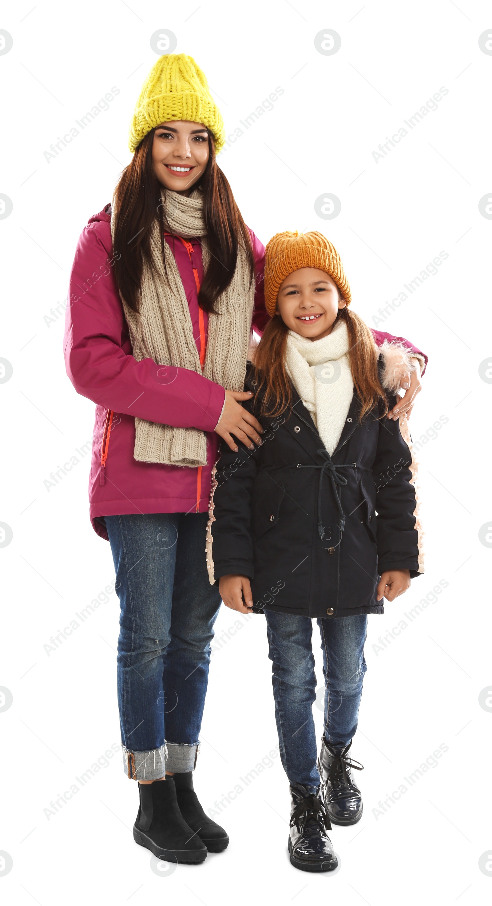 Photo of Happy mother and daughter in warm clothes on white background. Winter vacation