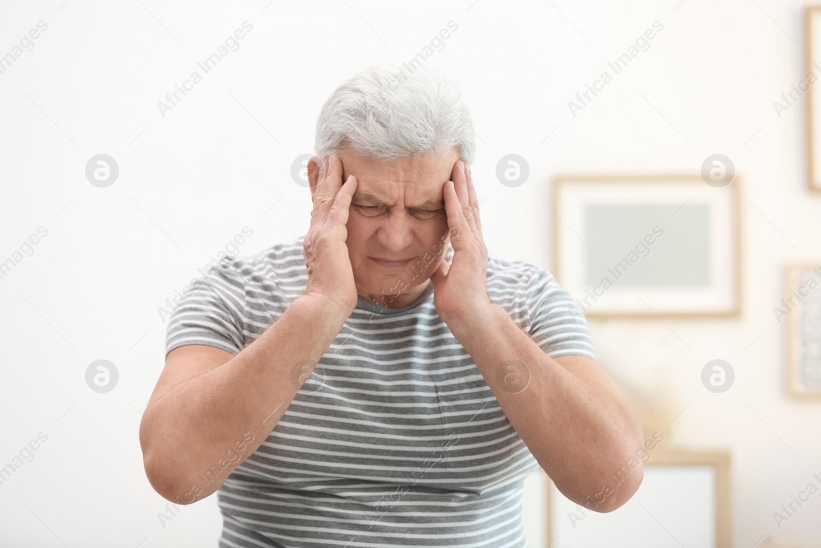 Photo of Mature man suffering from headache at home