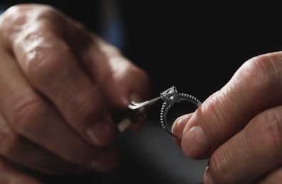 Photo of Professional jeweler working with ring, closeup view