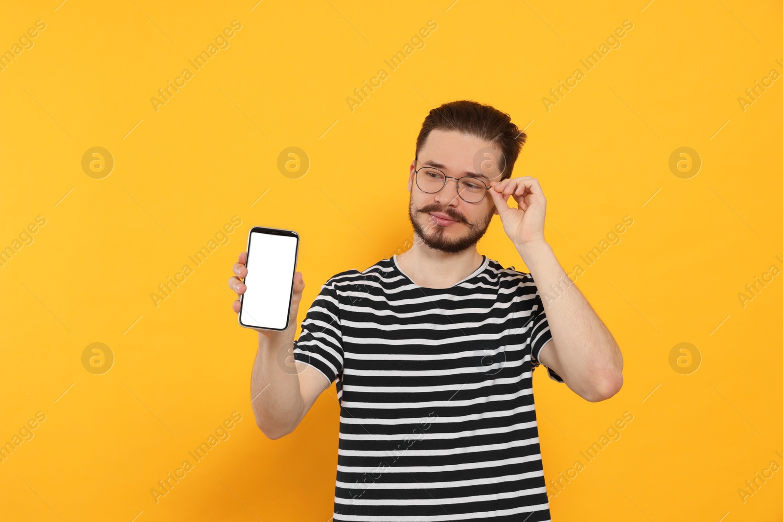 Photo of Smiling man with smartphone on orange background