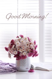 Good morning! Beautiful bouquet and open book on white wooden table near window