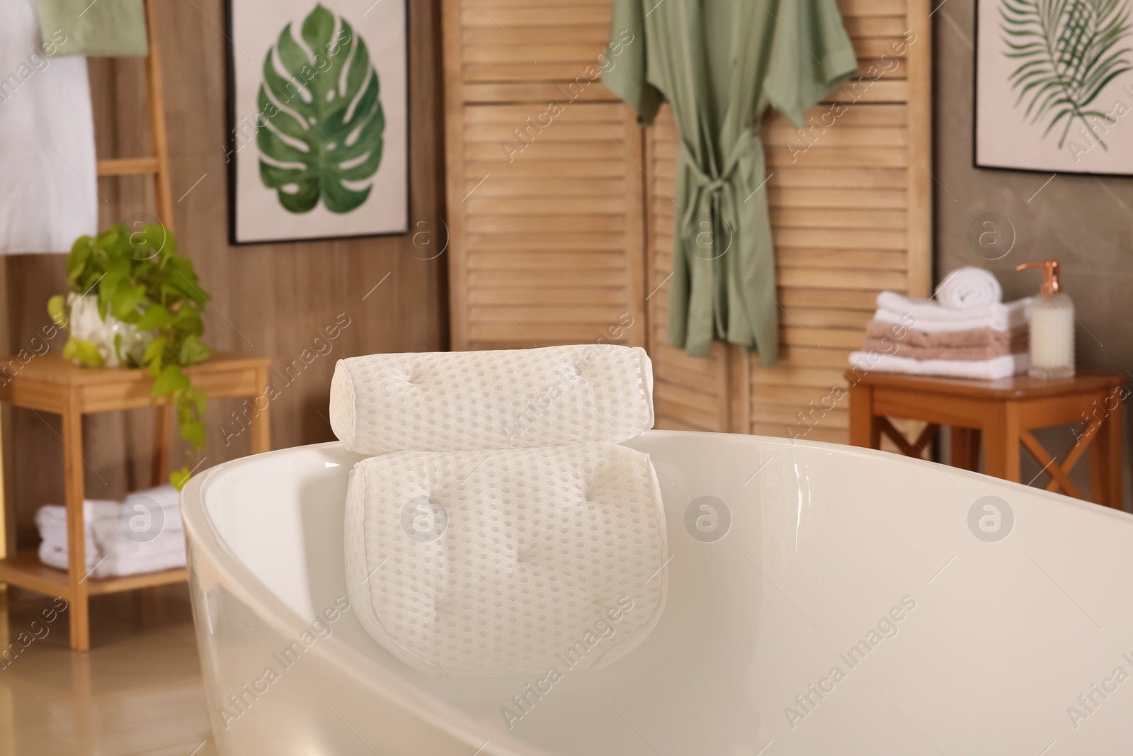 Photo of White tub with soft bath pillow indoors