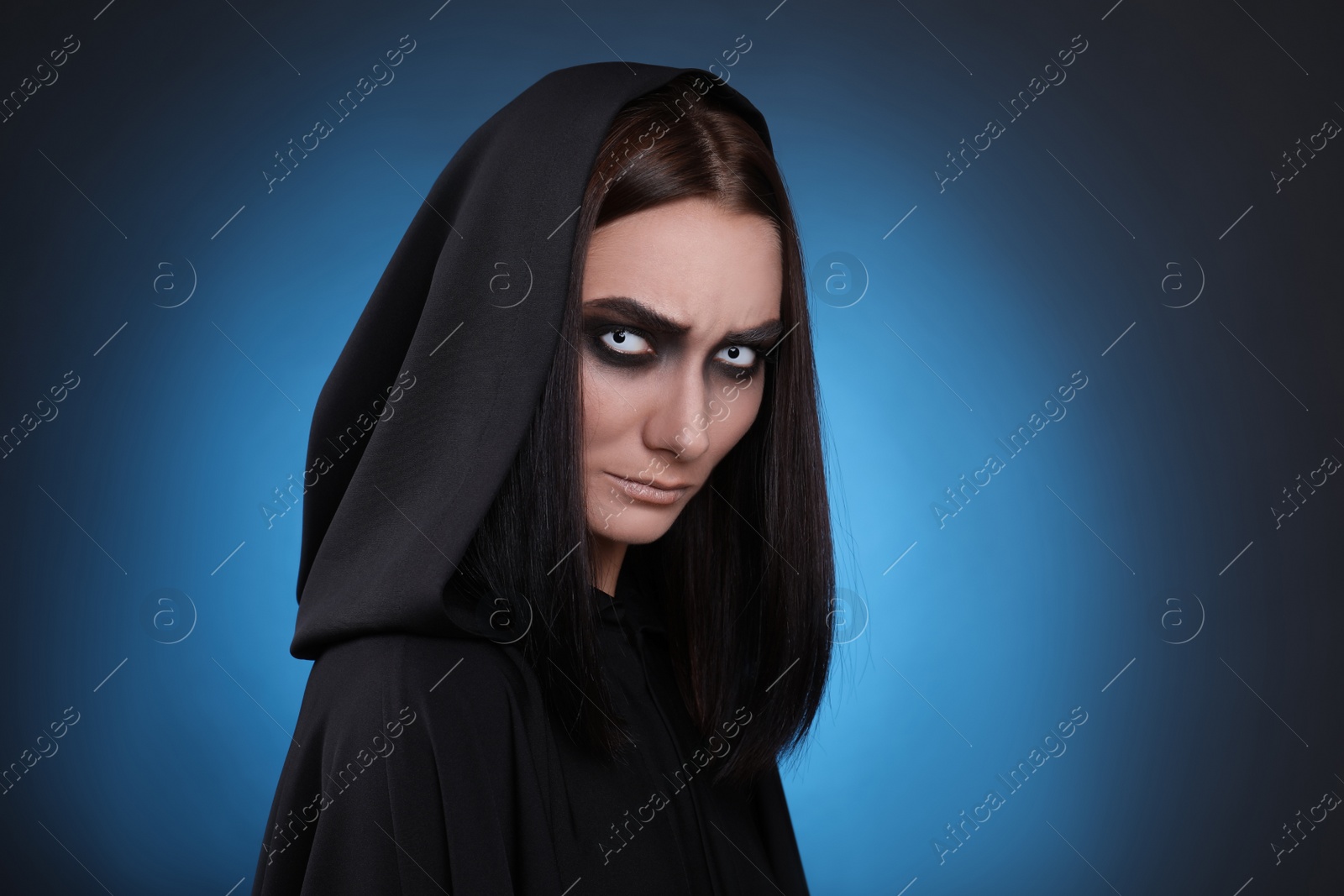 Photo of Mysterious witch with spooky eyes on color background, space for text
