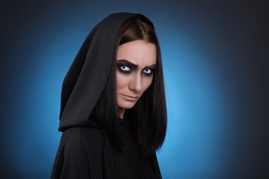 Photo of Mysterious witch with spooky eyes on color background, space for text