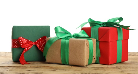 Different Christmas gifts on wooden table against white background