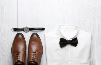 Photo of Flat lay composition with wedding shoes on white wooden floor
