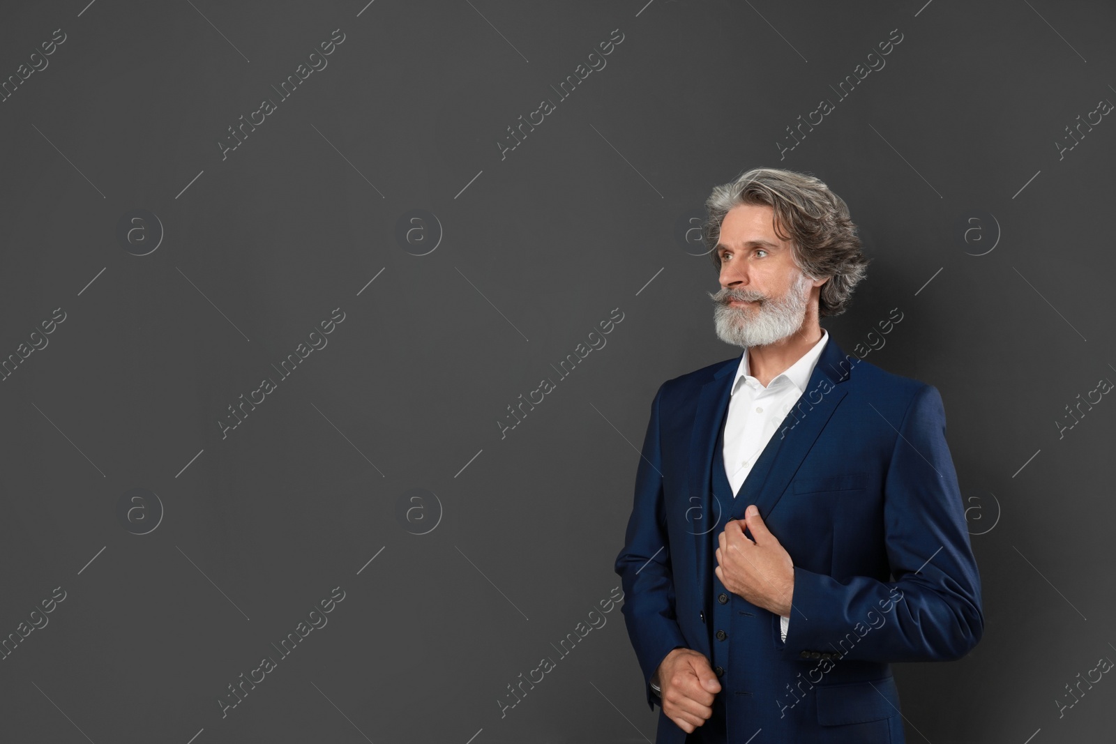 Photo of Portrait of handsome mature man on dark background. Space for text