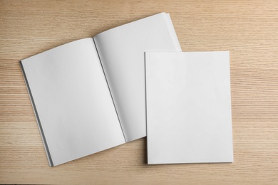 Photo of Open and closed blank brochures on wooden background, top view. Mock up for design