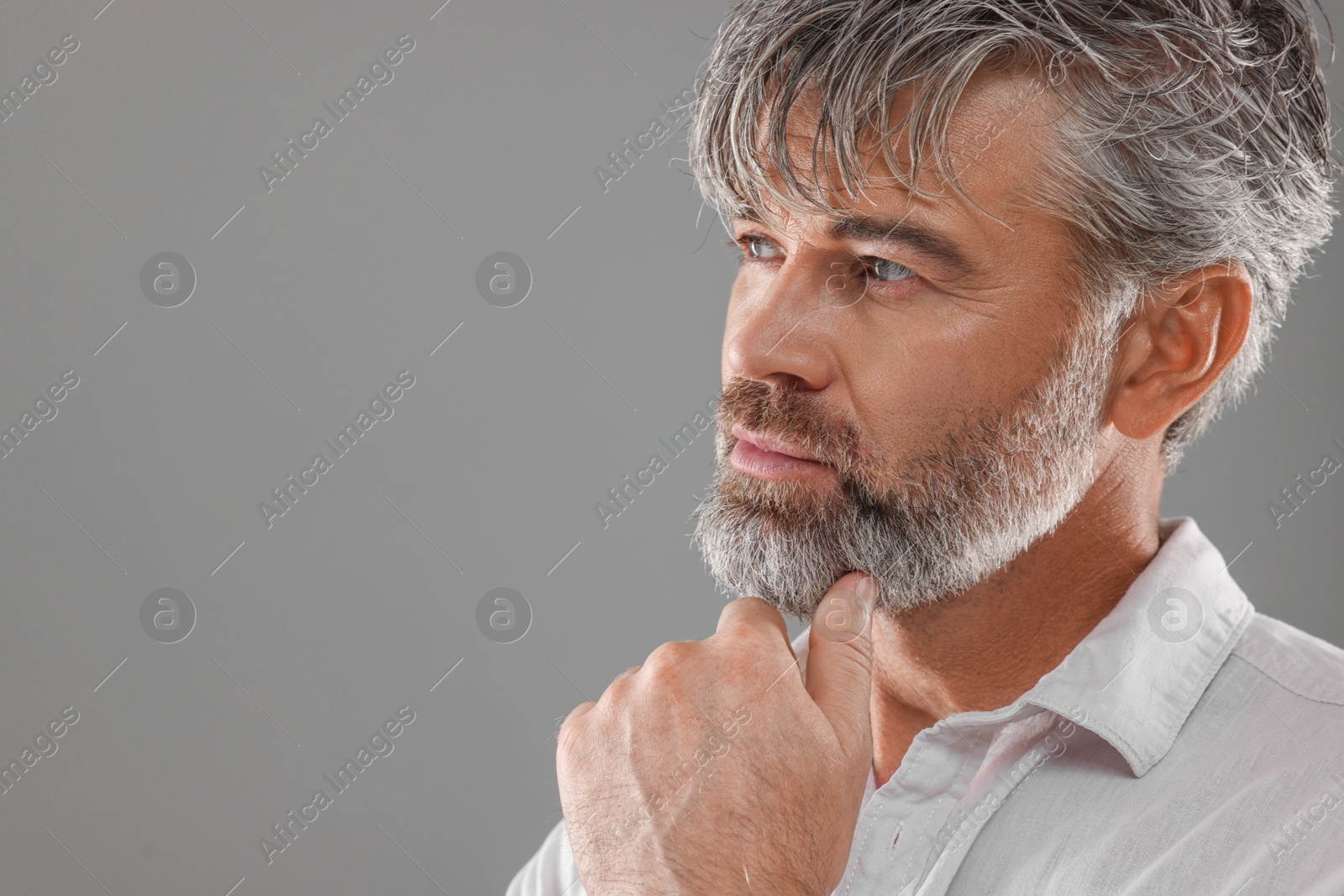 Photo of Portrait of confident man with beautiful hairstyle on light grey background. Space for text