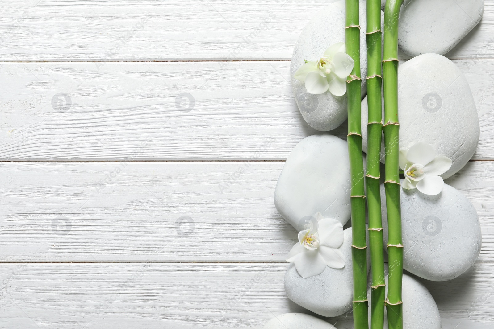 Photo of Flat lay composition with green bamboo stems on wooden background. Space for text