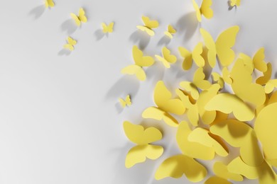 Photo of Yellow paper butterflies on white background, top view. Space for text
